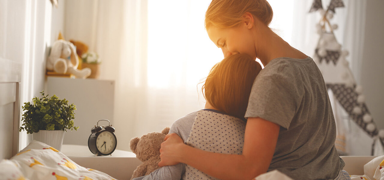 Mum Hugging Toddler On Bed